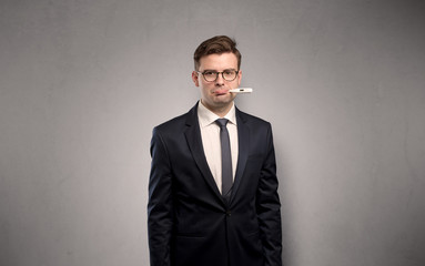Young tired businessman with thermometer and copy space
