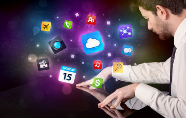 Male hands touching interactive table with colorful application icons on it 