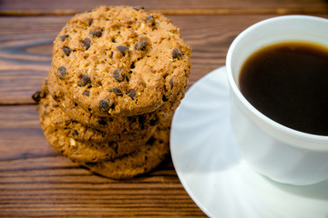 A cup of hot coffee stands on a wooden table 