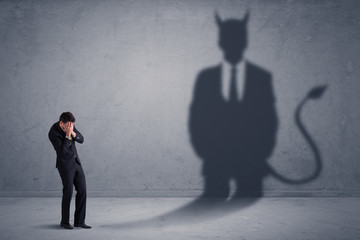 Fototapeta premium Business man looking at his own devil demon shadow concept background