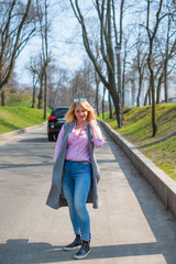 A woman of plus size, American or European appearance walks in the city enjoying life. A young lady with excess weight, xl size at the center of the city. Natural beauty  