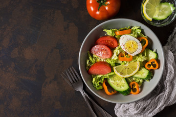 Fresh vegetable salad. Vegetarian dish. Water with cucumber and lemon, detox. Top view, dark background, space for text.
