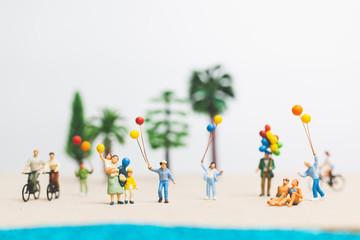 Miniature people : happy family enjoy summer vacation on the beach