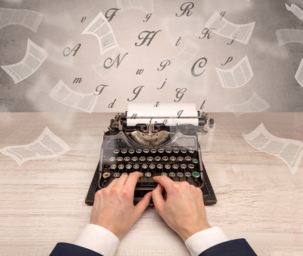 First person perspective hand typewriting with flying documents around
