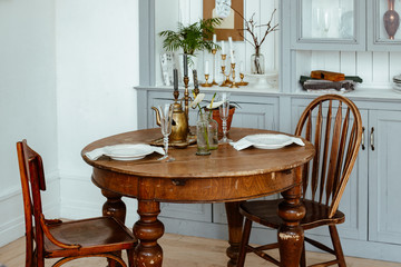 serving of a round vintage wooden table. cozy home interior, living room in bright colors.