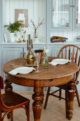 serving of a round vintage wooden table. cozy home interior, living room in bright colors.