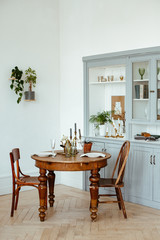 serving of a round vintage wooden table. cozy home interior, living room in bright colors.