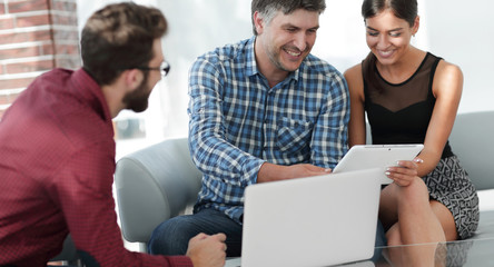 Business colleagues discussing on report with laptop on table