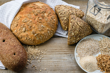 Naklejka premium Whole grain bread. Assortment of multi-grain bread on old wooden table. Сoncept of healthy eating.