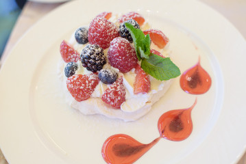 Pavlova cake with cream and berries