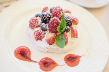 Pavlova cake with cream and berries