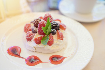 Pavlova cake with cream and berries