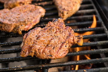 grilled pork with flames on barbecue