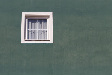 White window on an old green stucco wall as background