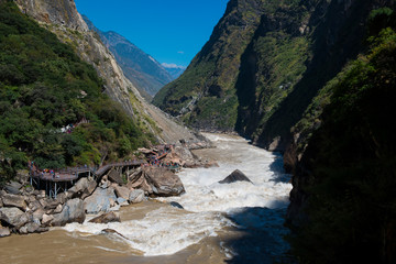 Tiger Leaping Gorge near Lijiang Ancient Town. One of the deepest canyons in the world. A rock in the middle of Golden Sand River called Tiger Leaping Rock in Lijiang, Yunnan, China