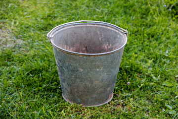 empty zinc bucket on green grass