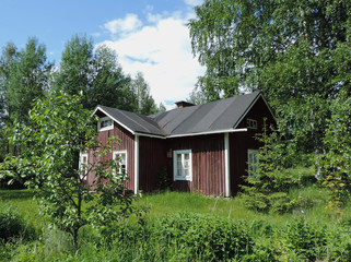 Old Finnish farm house standing empty on a summer day