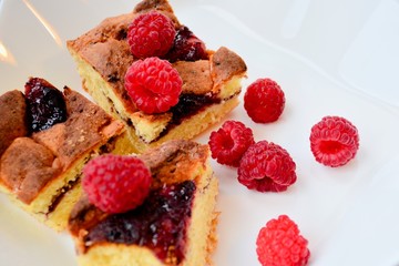 Raspberry and pieces of pie on white dish, macro view