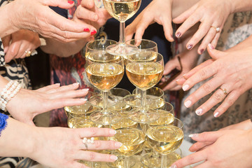 Female hands around glasses with champagne