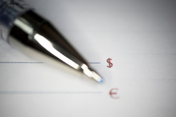 pen lies on a document or notebook, two blank graphs and dollar and Euro signs