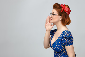 Sideways profile of attractive stylish young lady in vintage clothes calling someone, whispering...