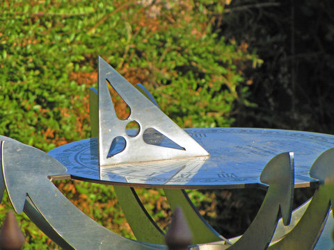 Sundial in summer day on tree background