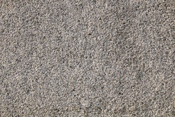 The texture of the stones and cobblestones. Fragment of a gray granite wall.