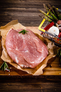 Fresh raw pork on cutting board on wooden background