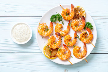 Grilled tiger shrimps skewers with lemon