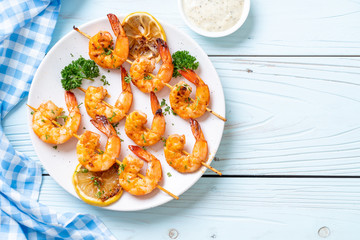Grilled tiger shrimps skewers with lemon