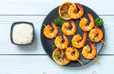 Grilled tiger shrimps skewers with lemon