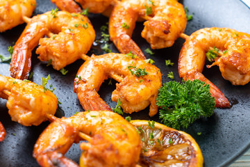 Grilled tiger shrimps skewers with lemon