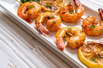 Grilled tiger shrimps skewers with lemon