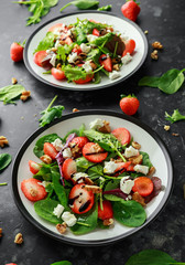 Summer Fruit Strawberry, spinach Salad with walnut, feta cheese balsamic vinegar, kale. in a plate. concepts health food