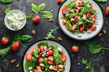 Summer Fruit Strawberry, spinach Salad with walnut, feta cheese balsamic vinegar, kale. in a plate. concepts health food