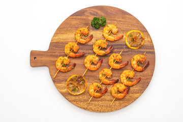 Grilled tiger shrimps skewers with lemon