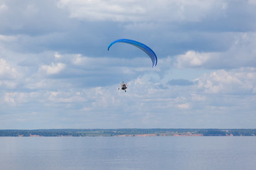 Paraglider over the river in the background of clouds