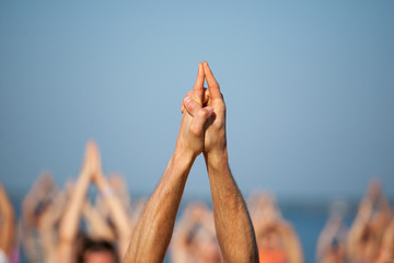 The teacher shows yoga asana to a group of people practicing yoga on the shore of the Gorky...