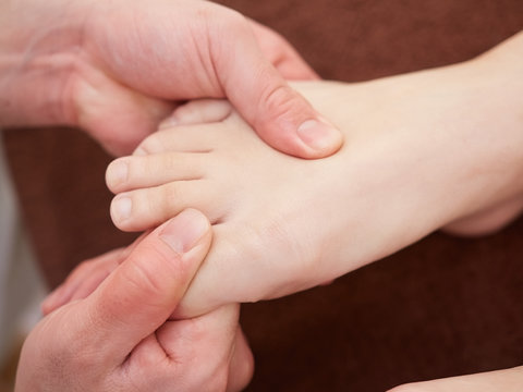 足の甲の指圧の施術を受ける女性