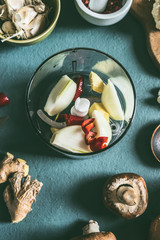 Spices mix in blender on kitchen table background with ingredients, top view. Cooking preparation.