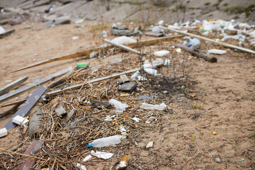 Various litter and trash throughout piece of ground of some abandoned place
