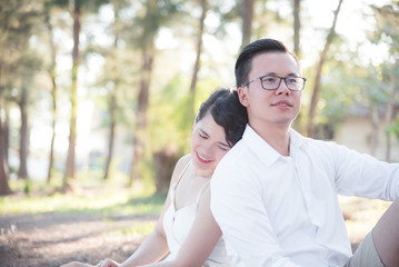 Asian couple ,man and woman sitting together in park