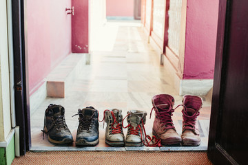 modern casual boots on the floor at hotel doorstep. Pink white and black color, dirty after long...