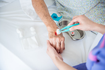 Closeup of nurse's hands dressing wound for patient's hand with injury