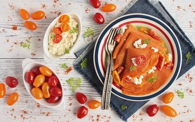 Delicious tomato juice crepes with cottage cheese and fresh cherry tomatoes