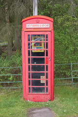 Defibrillator in telephone phone booth box red vintage save life heart attack emergency help in rural countryside Scotland uk