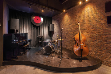 Modern jazz bar interior design, stage with black piano and cello - obrazy, fototapety, plakaty