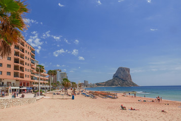 stone tower dominates the long beach of Calpe, Costa Blanca, Spain