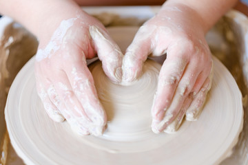 pottery handcraft hobby. hands forming and shaping a ball of clay on potter wheel