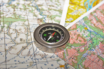 Obraz na płótnie Canvas Compass laying on a topographic map.